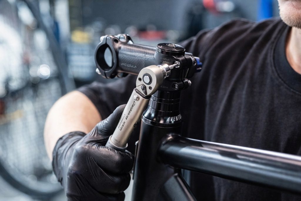 personne entrain de desserrer une potence de vélo à l'aide d'un clé dynanométrique 