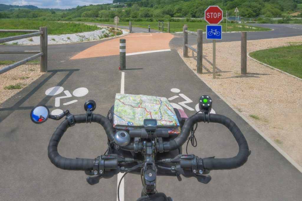 Guidon de vélo sur piste cyclable avec carte papier et GPS